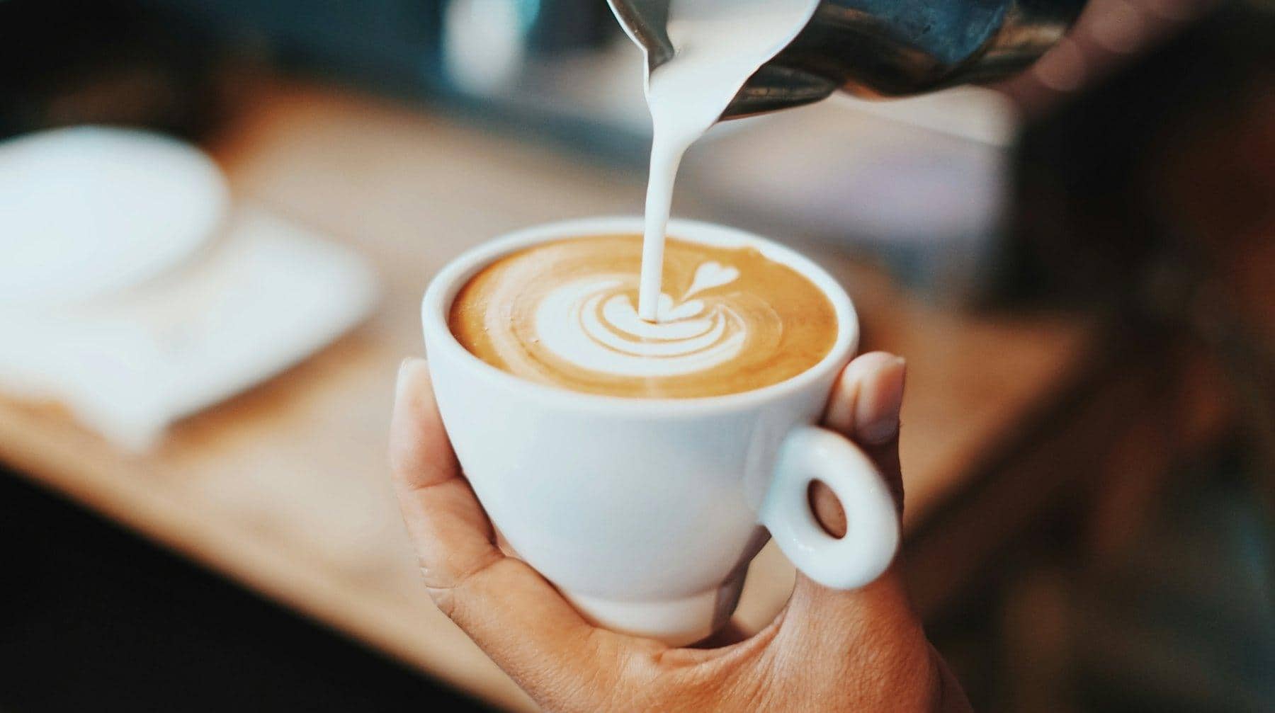 Barista versant le lait sur un espresso